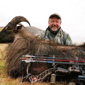 A man posing with the Tahr he harvested during his bow hunt in New Zealand.