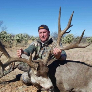 A man posing with the 14-point mule deer harvested on his Sonora, Mexico hunt.