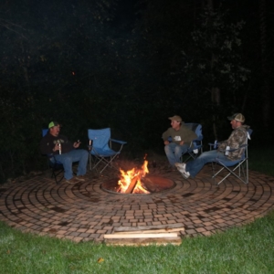 Three hunters gathered around a fire after a long successful day of hunting in Wisconsin.